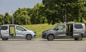 Dwa samochody Toyota Proace City Long w kolorach srebrnym i grafitowym stoją obok siebie z otwartymi drzwiami, ukazując wnętrze.