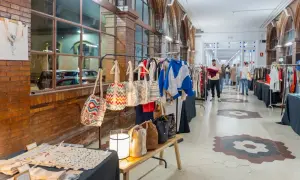 Mercado de artesanía con bolsos coloridos y ropa, evocando las tradiciones de Málaga.