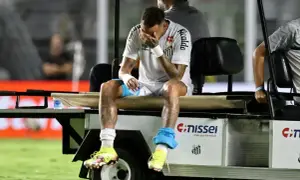 Neymar siedzi na wózku golfowym, trzymając się za twarz. Wygląda na to, że doznał kontuzji, która uniemożliwia mu dalszą grę.
