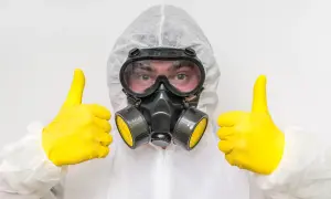 Osoba w kombinezonie ochronnym i masce gazowej daje kciuki w górę. Czy toksyk wie, że jest toksykiem?