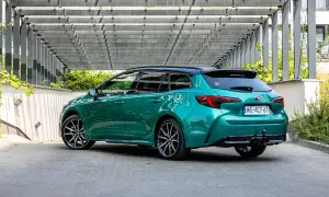 Zielona Toyota Corolla kombi z czarnym dachem, zaparkowana pod nowoczesną pergolą. Sprawdź atrakcyjną toyota corolla cena!