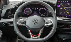 Kierownica VW z cyfrowymi zegarami i nawigacją. Zastanawiasz się, ile kosztuje obszycie kierownicy? Ten model ma sportowe akcenty GTI.
