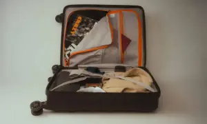 Otwarta walizka z ubraniami, paszportem i torbą z napisem "CRAZY". Sprawdzam, czy mój bagaż Ryanair zmieści się w cenie.