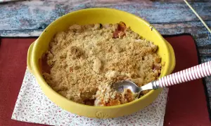 Ein goldbrauner Obst-Crumble im gelben Auflaufform, bereit zum Genießen. Dieses Crumble Rezept sieht köstlich aus!