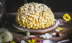 Torta mimosa, una delizia soffice ricoperta di cubetti di pan di Spagna e zucchero a velo, pronta per essere gustata.