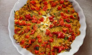 Alici al forno dorate e succulente, ricoperte di pomodorini freschi e pangrattato croccante. Un piatto semplice e gustoso.