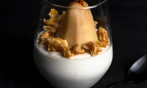 Ein köstlicher Nachtisch mit einer ganzen Birne auf cremigem Joghurt, garniert mit karamellisierten Nüssen.