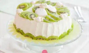 Tort ozdobiony plasterkami kiwi i bezą. Świeże dekoracje z kiwi na torcie dodają mu lekkości i koloru.