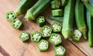 Okra co to? Zielone, podłużne strąki pokrojone w poprzek, ukazujące charakterystyczny, pięcioramienny kształt z nasionami.