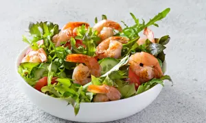 Salade de crevettes fraîche et colorée, garnie de légumes croquants et de tomates juteuses.