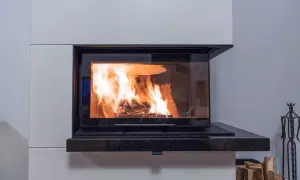 Nowoczesny komin do kominka z płaszczem wodnym, w którym płonie ogień, ogrzewając dom.