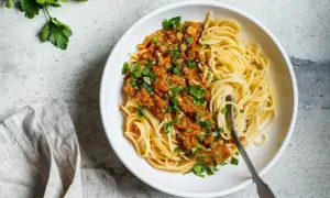 Porcja spaghetti z sosem z soczewicy i warzyw, posypana natką pietruszki. Pyszne i zdrowe spaghetti kcal.