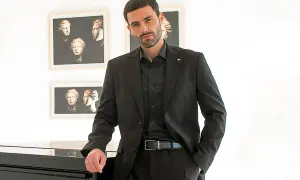 Uomo con abito nero, camicia e cravatta abbinati. Eleganza senza tempo.
