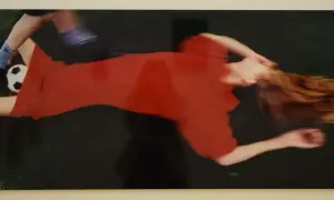 Boris Mikhailov cattura un momento di movimento sfocato: una donna in abito rosso e un piede con pallone da calcio.