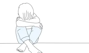 Ilustracja dziecka siedzącego ze zwieszoną głową i skrzyżowanymi nogami.
