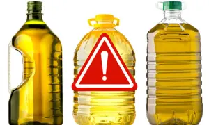 Bottiglie di olio di oliva con un cartello di pericolo. Attenzione all'olio di oliva lampante, potrebbe non essere quello che pensi.