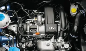 Silnik 1.2 TSI EA211 z turbosprężarką. Widoczne elementy układu chłodzenia, dolot powietrza i osłona silnika z napisem TSI.
