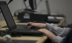 Dłonie piszą na klawiaturze laptopa, jakby w pośpiechu, jakby ktoś prowadził **stalking** w sieci.