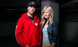 Tomasz Chada z żoną, w ciemnym korytarzu. On w czerwonej bluzie i czapce, ona w czarnej kurtce.