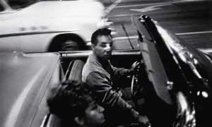 Garry Winogrand uchwycił nocną jazdę kabrioletem. Mężczyzna za kierownicą, kobieta obok. Rozmyte światła miasta.