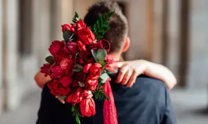 Piękny bukiet czerwonych róż i tulipanów, idealne kwiaty na randkę, w dłoniach obejmujących ukochanego.