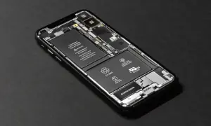Rozłożony iPhone SE z widoczną baterią i podzespołami.