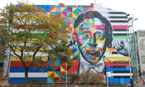 Kolorowe murale w Polsce zdobią budynek. Twarz mężczyzny podzielona na geometryczne wzory i klawisze fortepianu.
