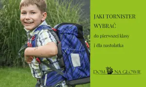 Uśmiechnięty chłopiec w kratkę z niebieskim tornistrem na plecach.