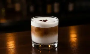 En krämig White Russian med kaffebönor på toppen, perfekt för en mysig kväll.