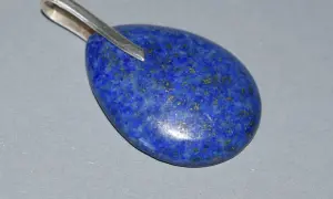 Owalny wisiorek z lapis lazuli, kamienia o intensywnie niebieskim kolorze i złotych inkluzjach. Jego właściwości od wieków cenione są w ezoteryce.