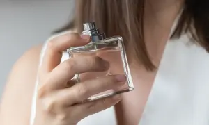 Kobieta testuje perfumy, szukając idealnego zapachu dla siebie. Elegancka buteleczka w dłoni.
