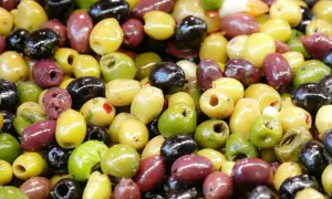 Un assortimento colorato di olive dolci varietà: verdi, nere e viola, alcune denocciolate, pronte per essere gustate.