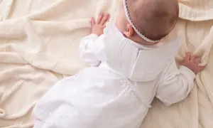 Uroczy niemowlak w białym stroju aniołka, idealny na chrzest. Matka chrzestna znajdzie tu inspirację, co potrzebne do chrztu.