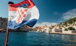 Chorwacka flaga na tle Dubrownika. Idealne miejsce, by pomyśleć, co zabrać na wakacje do Chorwacji.