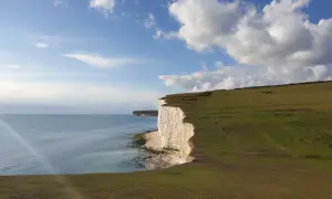 Majestatyczne białe klify w Sussex, morze i błękitne niebo z chmurami.