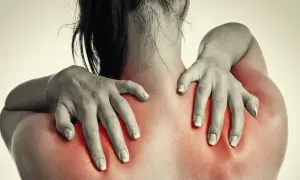 Frauenhände massieren schmerzende Schultern, die rot aufleuchten. Magnesium kann bei Hexenschuss Linderung verschaffen.