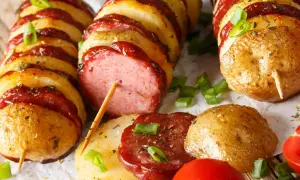 Kiełbasa i ziemniaki na patyku, zapiekane z sosem. Pyszny pomysł, co można zrobić z kiełbasy na obiad.