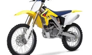 Żółto-biały motocykl enduro z niebieskim siedzeniem na białym tle.