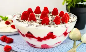 Himbeer Baiser Nachtisch in einer Glasschüssel, garniert mit frischen Himbeeren und Schokostückchen. Ein Traum!