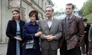 Wojenne dziewczyny obsada: cztery postacie w strojach z epoki, dwie kobiety i dwóch mężczyzn, pozują na tle kamienicy.