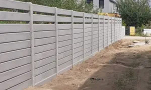 Nowy, nowoczesny ogrodzenie systemowe betonowe tworzy solidną barierę.