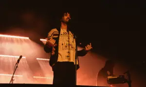 Kevin Parker z Tame Impala na koncercie w Gliwicach, w świetle reflektorów.