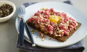 En läcker råbiff på mörkt bröd med en gul äggula i mitten. Perfekt för dig som söker ett gott råbiff recept.