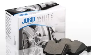 Dwa klocki hamulcowe Jurid White, wykonane z materiałów ceramicznych, leżą obok pudełka z tymi samymi klockami.