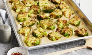 Gerösteter Brokkoli mit Käse auf einem Backblech. Perfekt zum **Brokkoli braten** für eine gesunde Beilage.