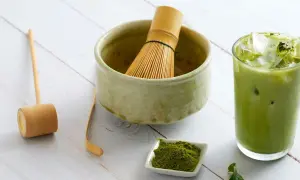 Akcesoria do przygotowania matcha: bambusowa miotełka, miarka, miseczka z proszkiem i szklanka z zielonym napojem. Idealny przepis na matche.