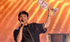 Zwycięzcy Eurowizji, młody artysta z mikrofonem i pucharem, świętuje triumf na scenie.