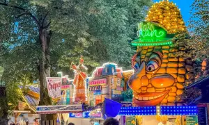 Buntes Volksfest mit Maiskolben-Figur und Buden. Das bergkirchweih erlangen programm lockt mit Leckereien.