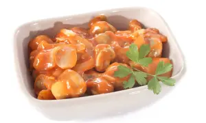 Un plat de champignons à la grecque, tendres et savoureux, baignant dans une sauce tomate onctueuse, garni d'une touche de persil frais.