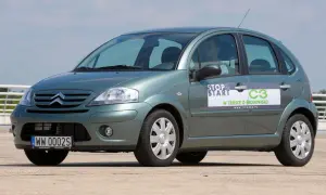 Zielony Citroen C3 z naklejką "Stop & Start" i informacją "W trosce o środowisko". Widać przednie żarówki.